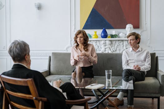 A couple conversing with a therapist in a chic, modern office setting.